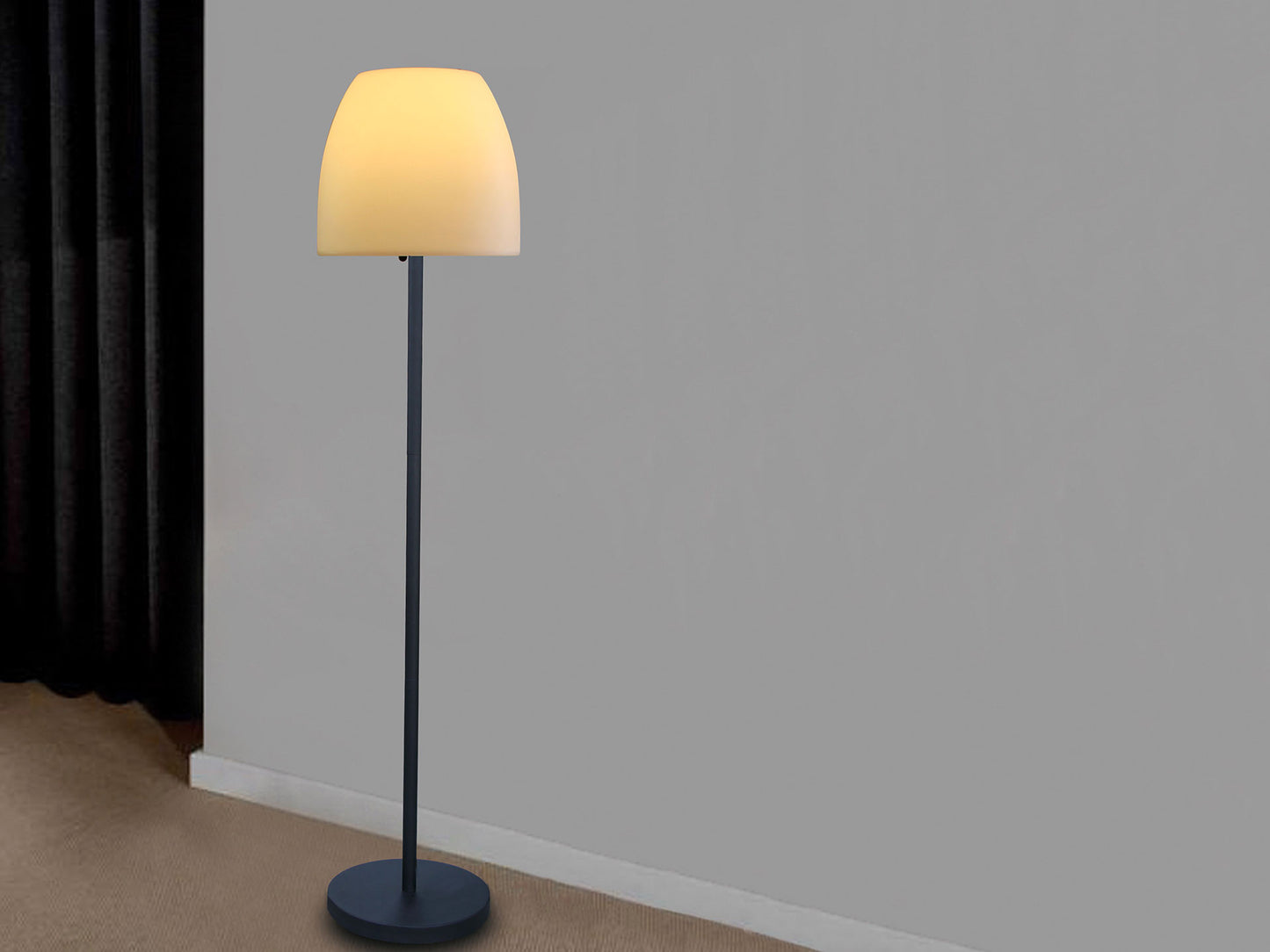 Floor lamp with a yellow shade against a gray wall.
